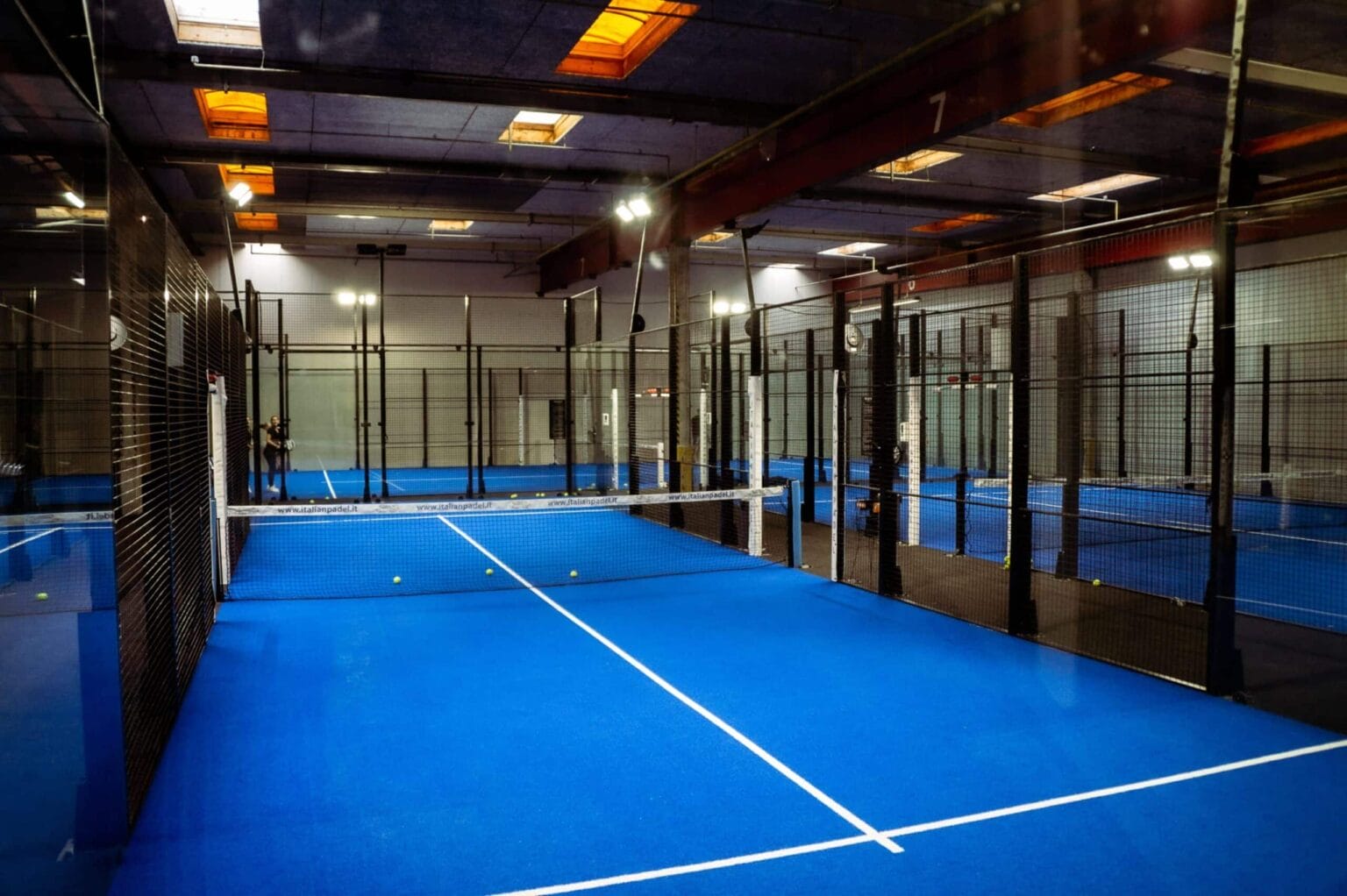 Indendørs padelbane med blåt gulv og net