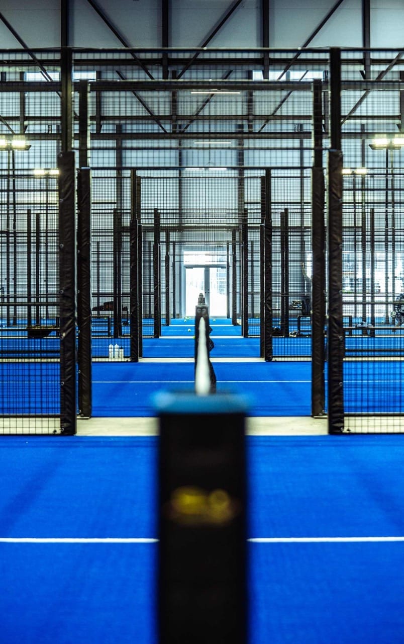 Indendørs padelbane med blå gulv og net