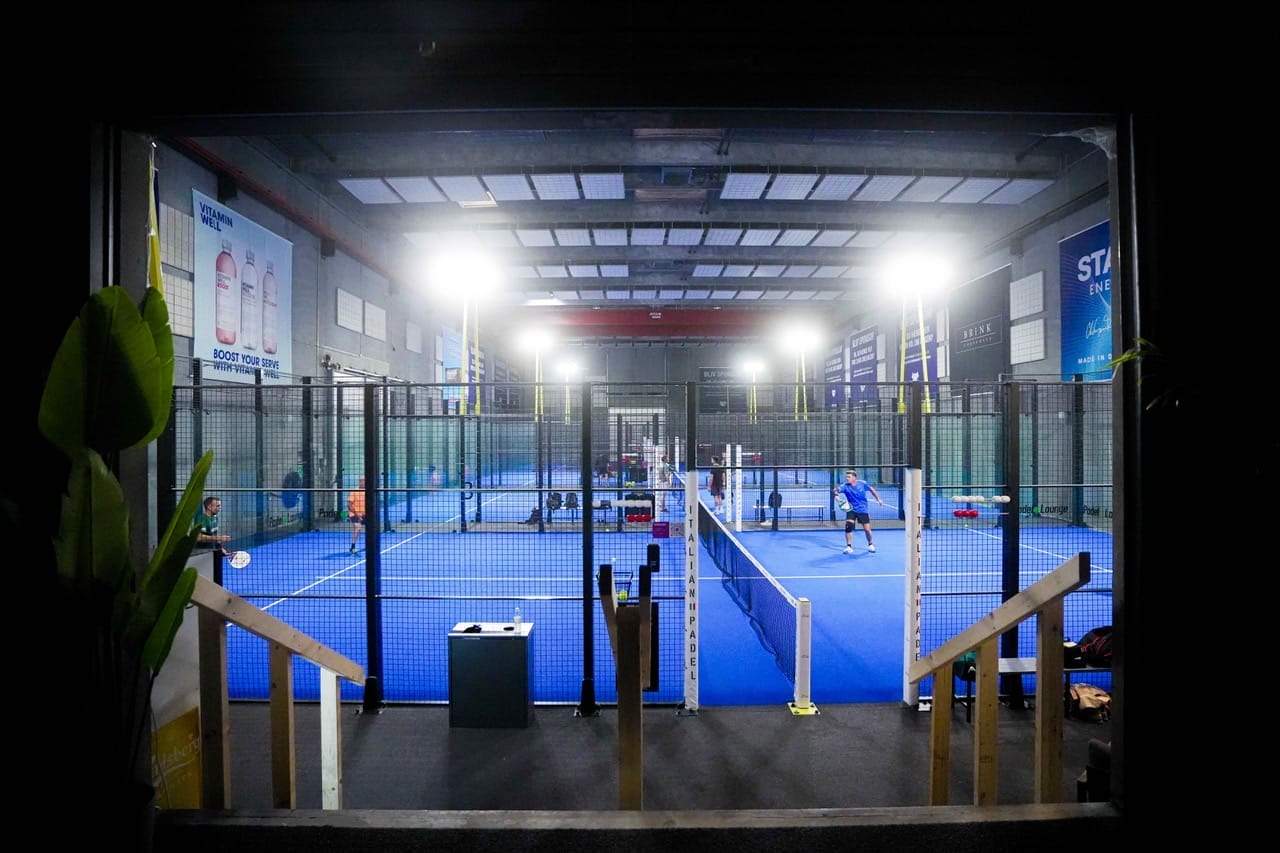 Folk spiller padel på indendørs bane