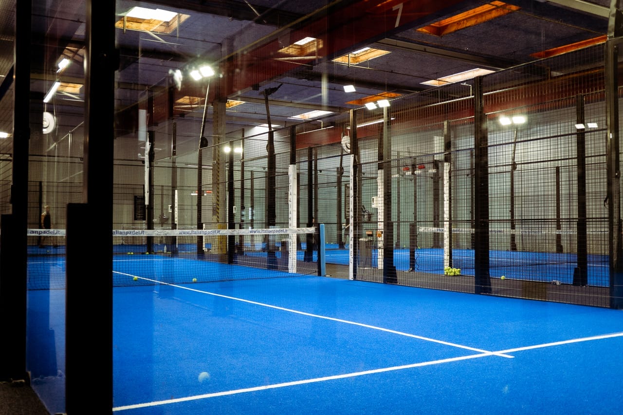 Indendørs padelbane med blåt underlag og net